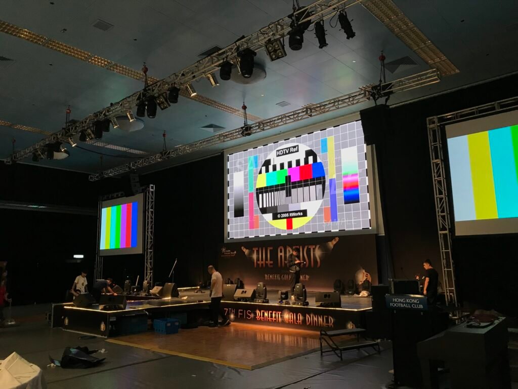 AV production team setting up audio and visual equipment for a live event.